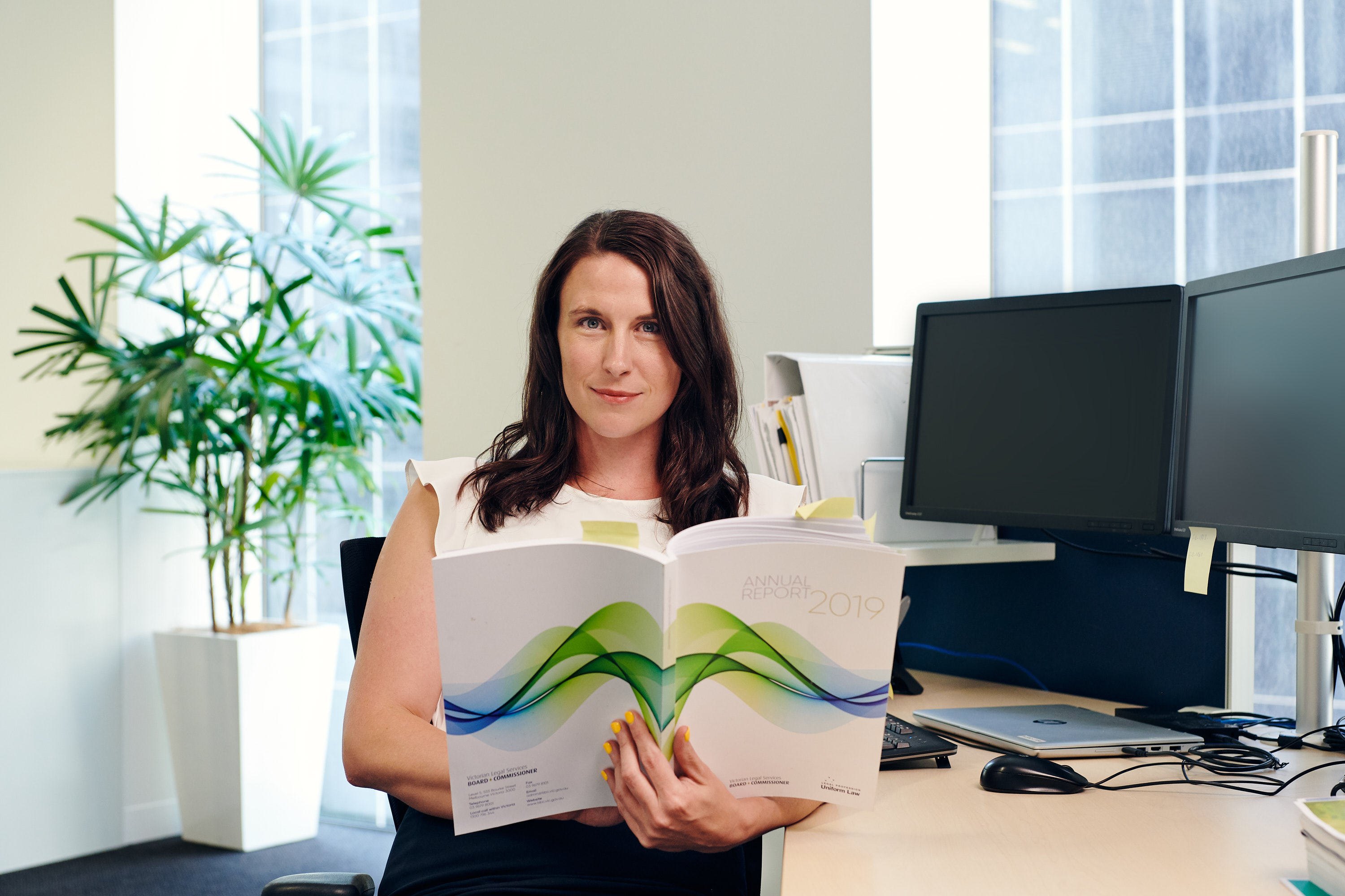 Woman reading document sitting at desk